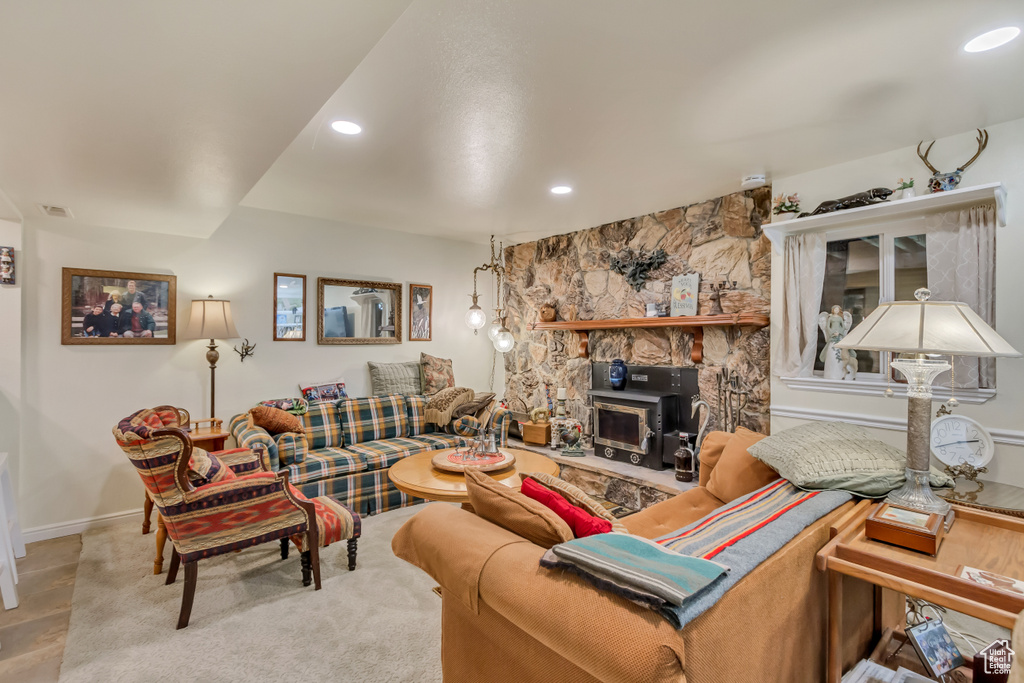 Living room featuring baseboards, a wood stove, and recessed lighting