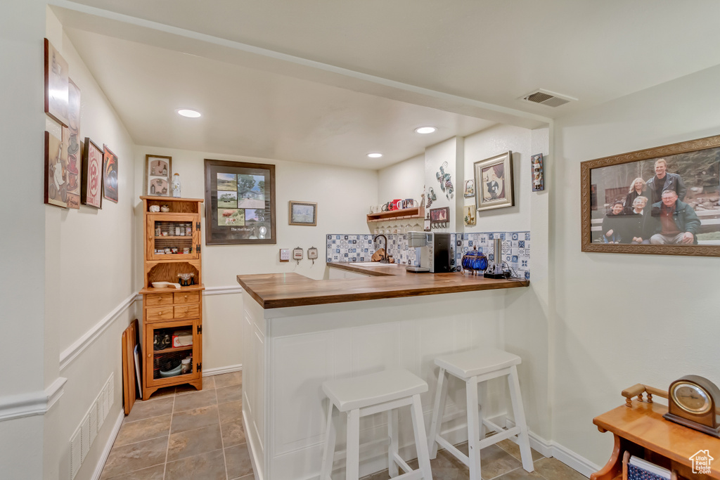 Bar with backsplash, a sink, visible vents, and recessed lighting