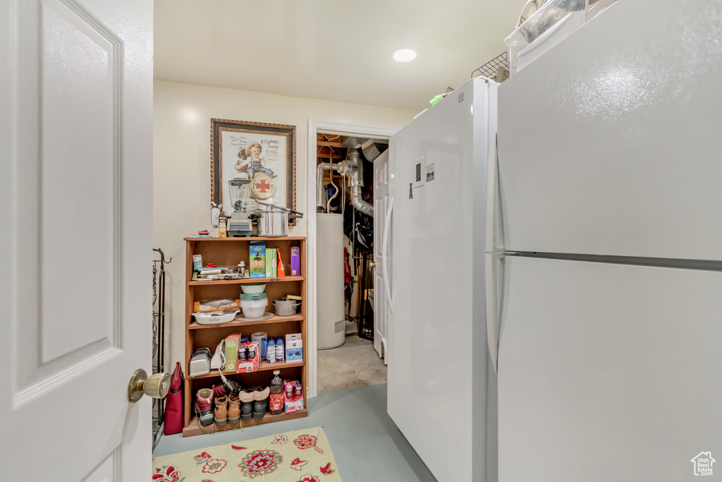 Hall featuring water heater, concrete floors, and recessed lighting