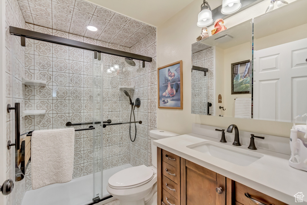 Full bath featuring a shower stall, toilet, and vanity
