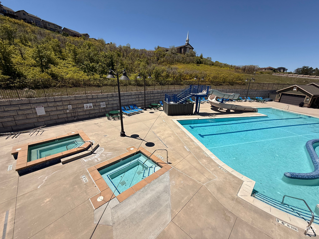 Community pool with a hot tub and a patio area