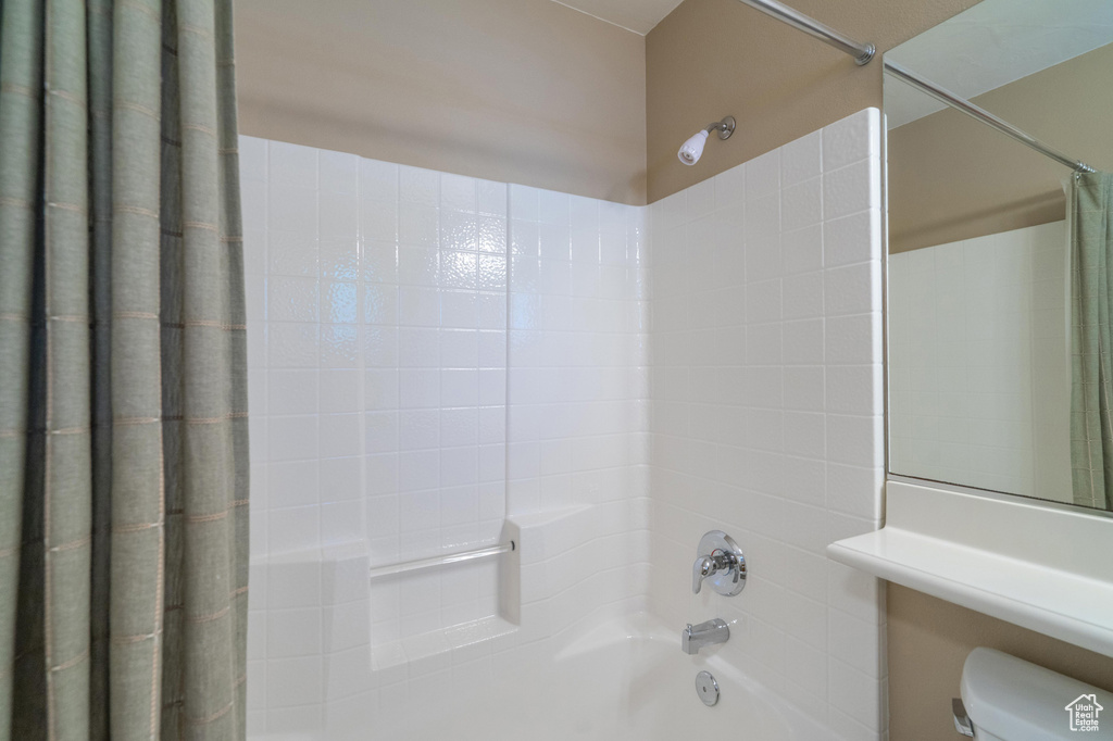 Full bath featuring shower / bath combo with shower curtain and toilet