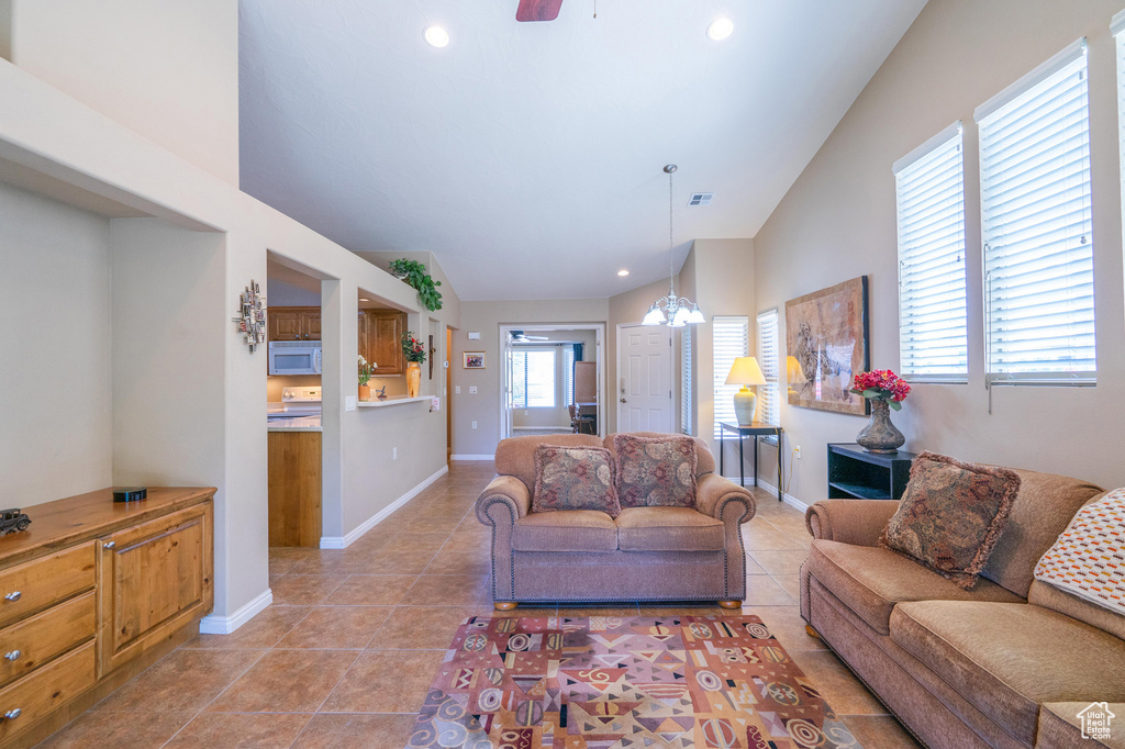 Living room with lofted ceiling, light tile patterned floors, baseboards, and recessed lighting