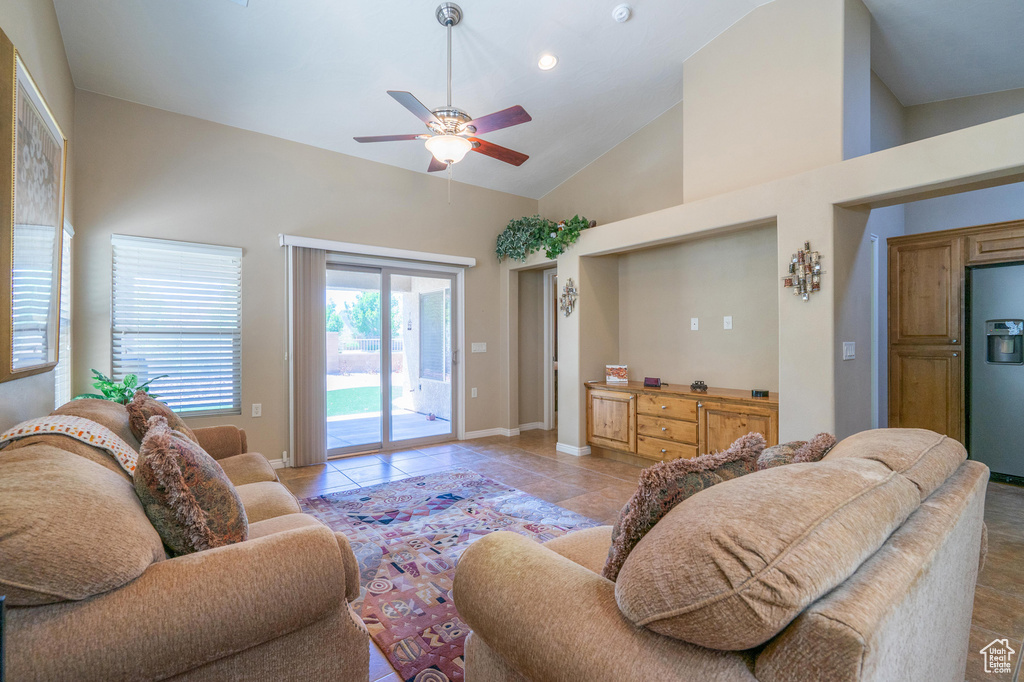 Living room featuring ceiling fan, baseboards, high vaulted ceiling, light tile patterned flooring, and recessed lighting