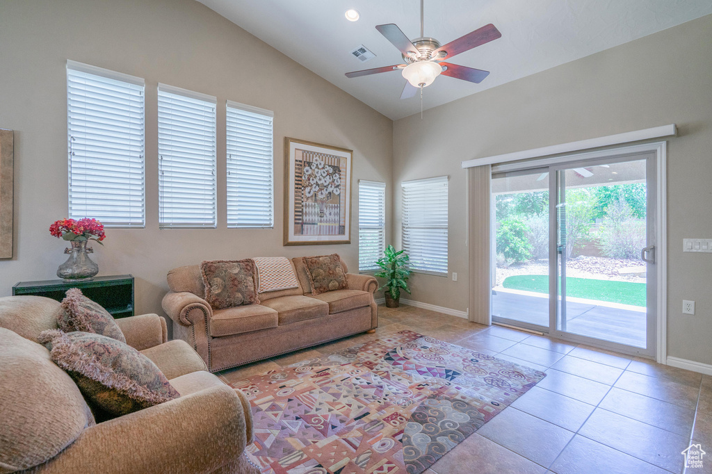 Living area featuring a ceiling fan, baseboards, tile patterned floors, and high vaulted ceiling
