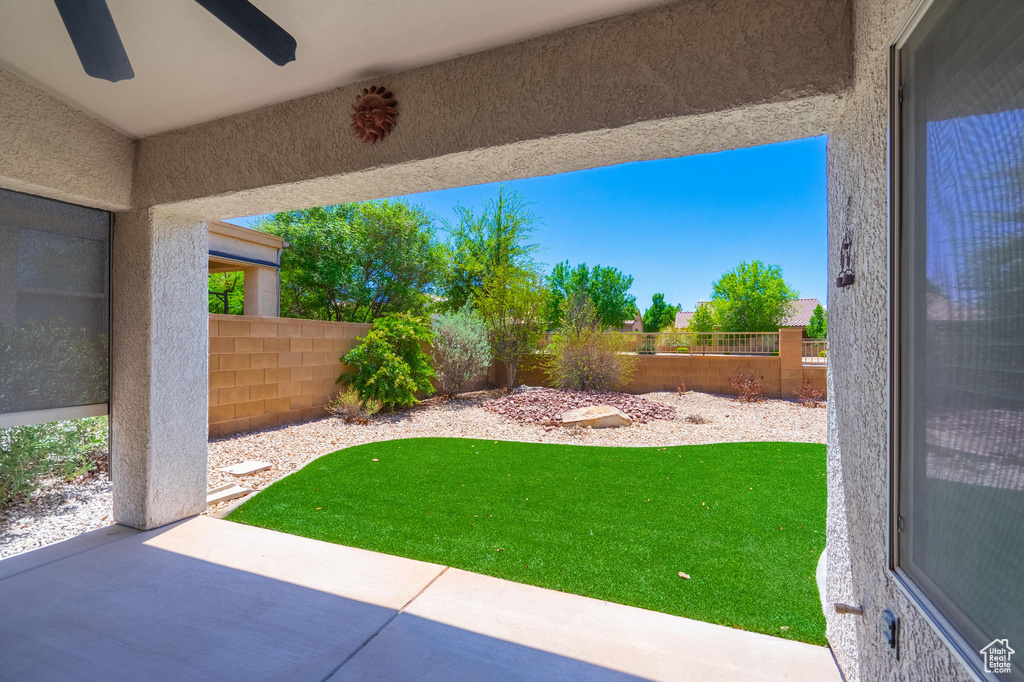 Fenced backyard featuring a patio and ceiling fan