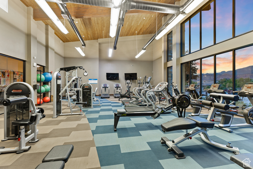 Gym with a towering ceiling, wooden ceiling, and carpet