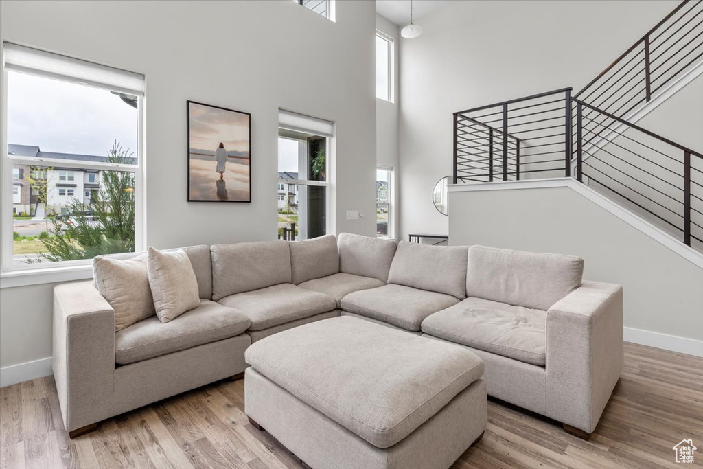 Living area with baseboards, light wood-type flooring, and plenty of natural light