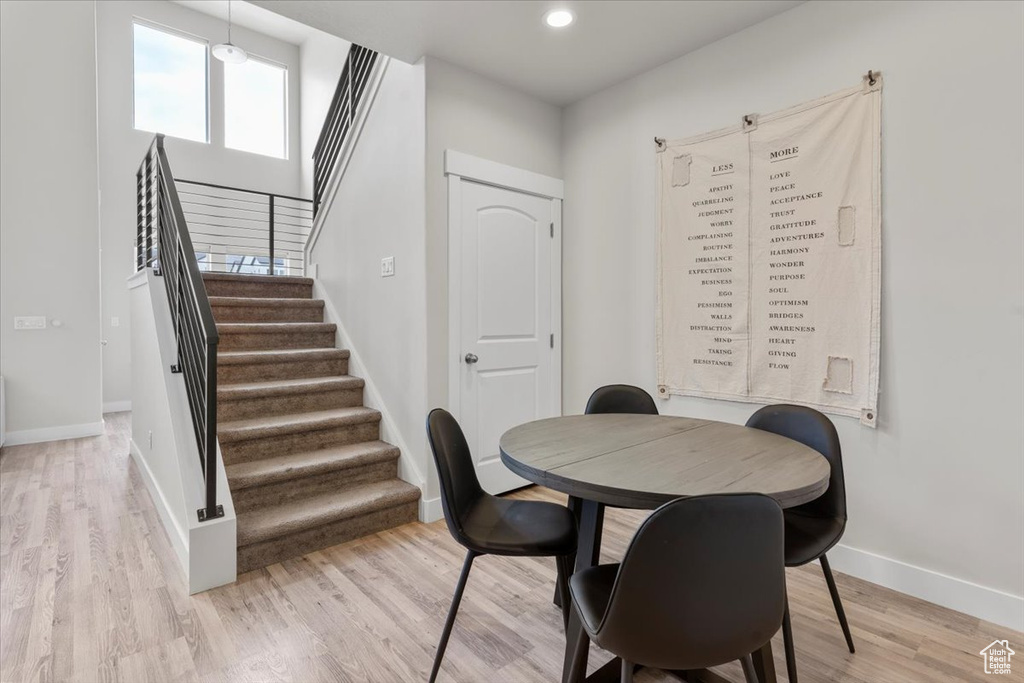 Dining space with recessed lighting, stairs, light wood finished floors, and baseboards