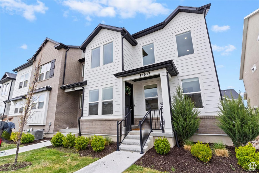 Townhome / multi-family property with central AC unit and brick siding