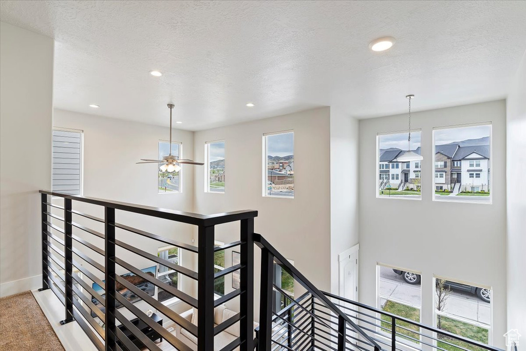 Staircase featuring recessed lighting, a wealth of natural light, and baseboards