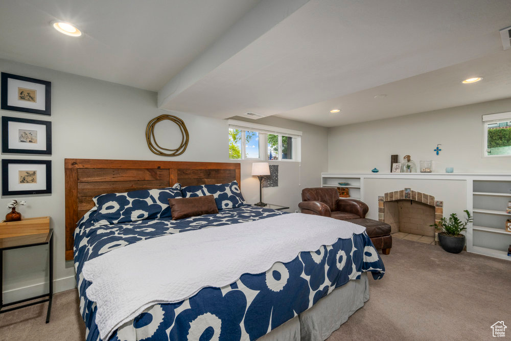 Carpeted bedroom featuring recessed lighting, visible vents, and a fireplace