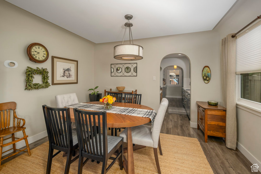 Dining space featuring baseboards, wood finished floors, and arched walkways