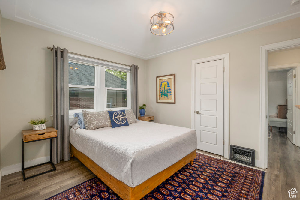 Bedroom featuring baseboards, wood finished floors, and visible vents