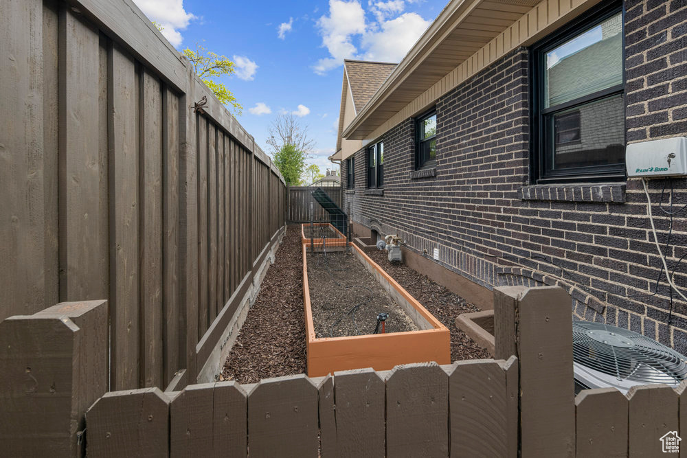 View of home\\\\\\\\\\\\\\\'s exterior with fence, a vegetable garden, and brick siding