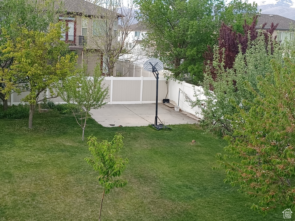 View of yard featuring fence and a patio area