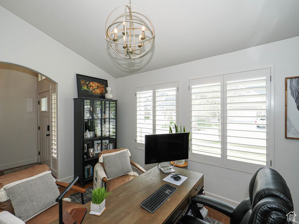 Home office with baseboards, arched walkways, vaulted ceiling, and an inviting chandelier