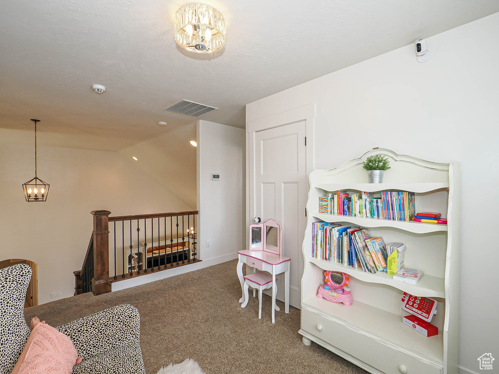 Recreation room with an inviting chandelier, vaulted ceiling, visible vents, and carpet
