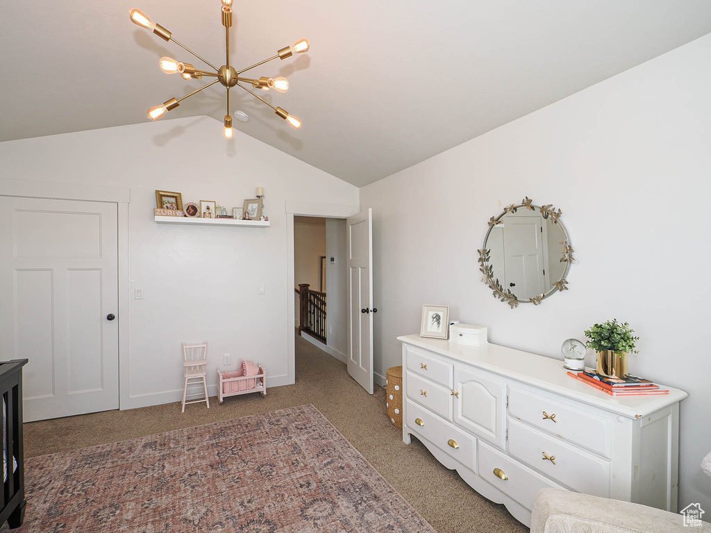 Bedroom featuring a chandelier, lofted ceiling, and light colored carpet