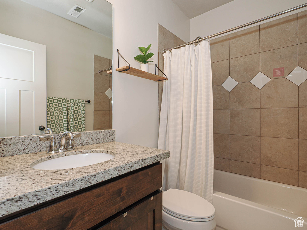Full bath with shower / tub combo, visible vents, vanity, and toilet