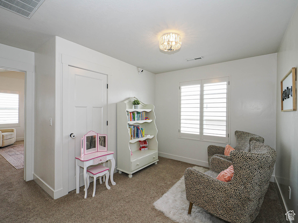 Sitting room with visible vents, carpet flooring, and a healthy amount of sunlight