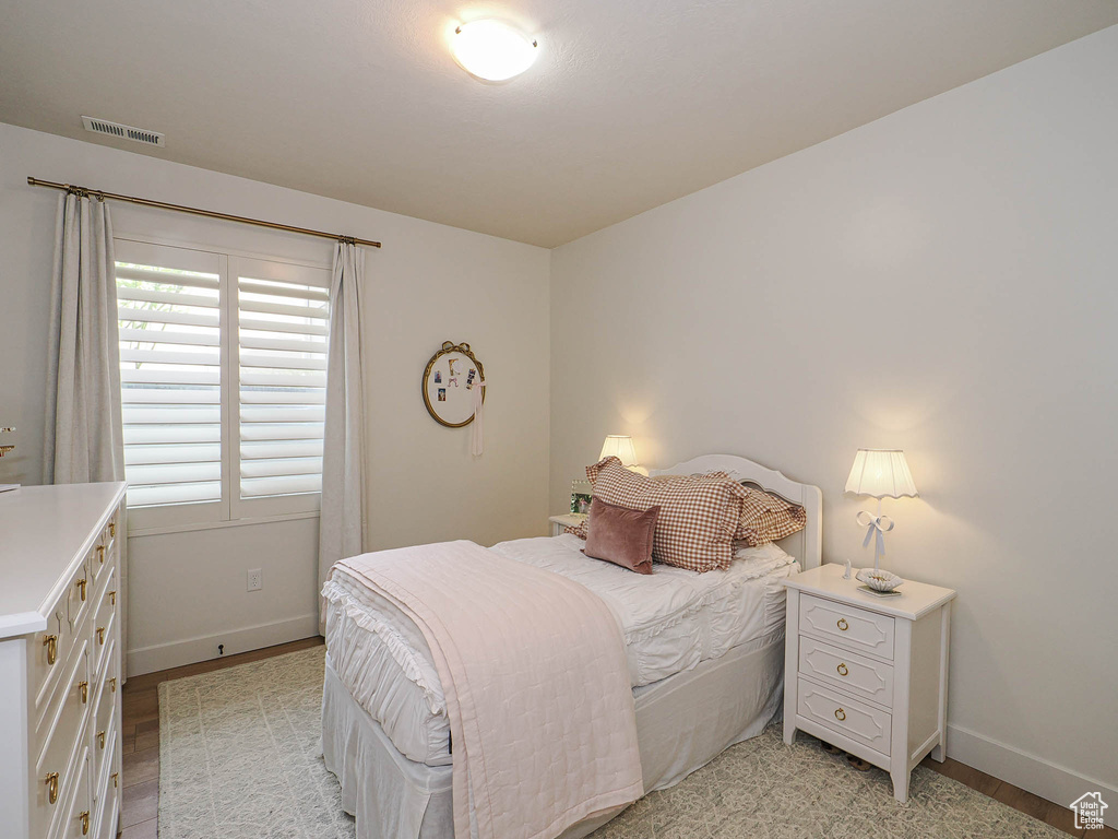 Bedroom with light wood-type flooring, visible vents, and baseboards