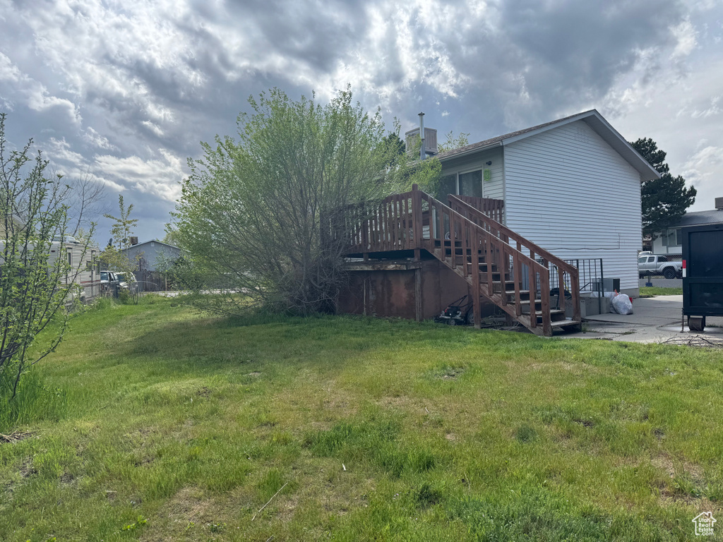 View of yard with stairway, a wooden deck, and a patio area