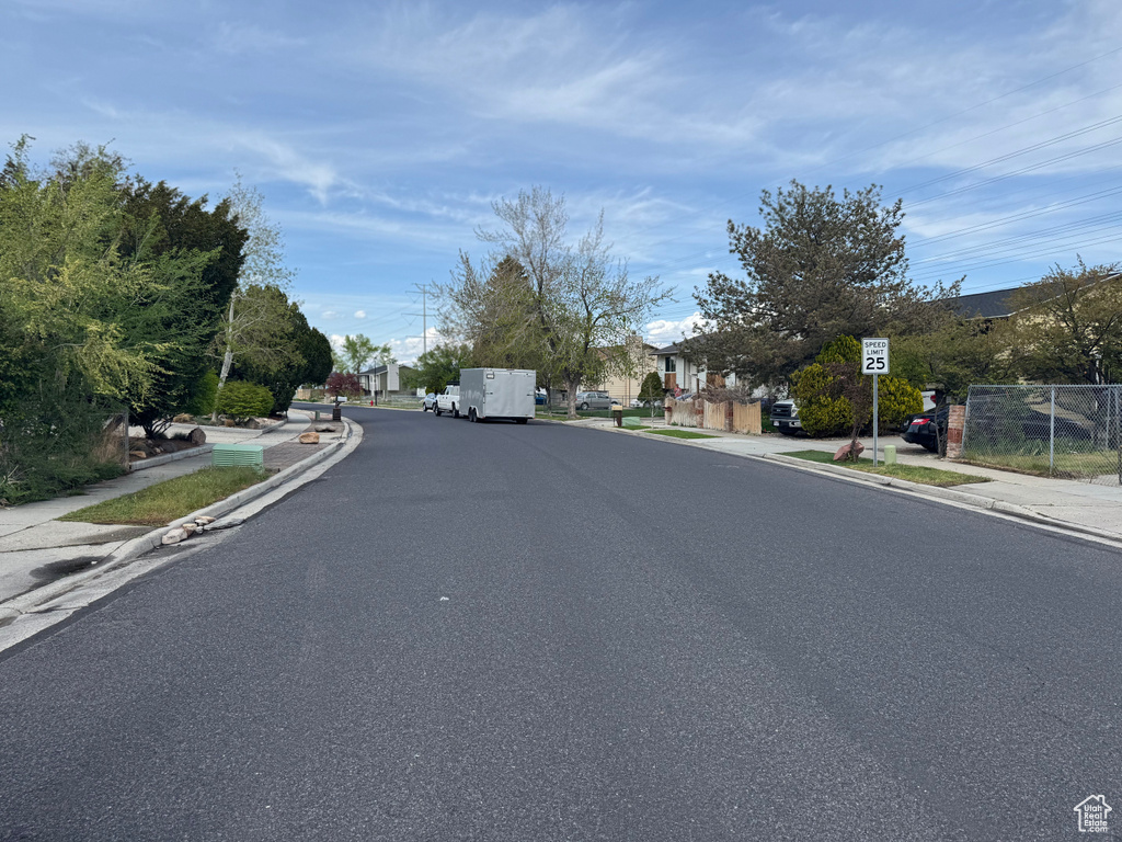 View of street with traffic signs, a residential view, curbs, and sidewalks