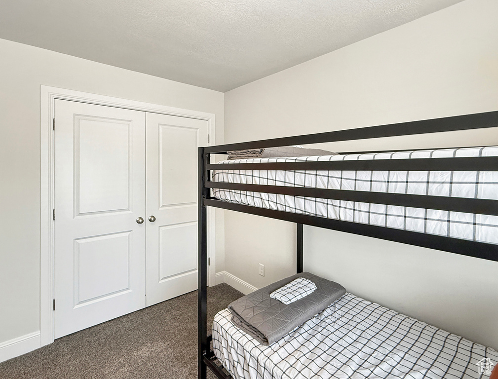 Bedroom featuring baseboards, carpet, and a closet