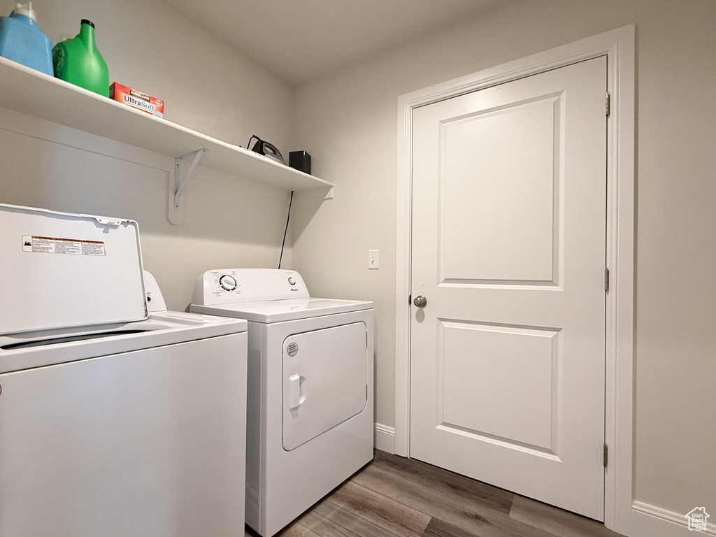 Clothes washing area featuring light wood finished floors, separate washer and dryer, and laundry area
