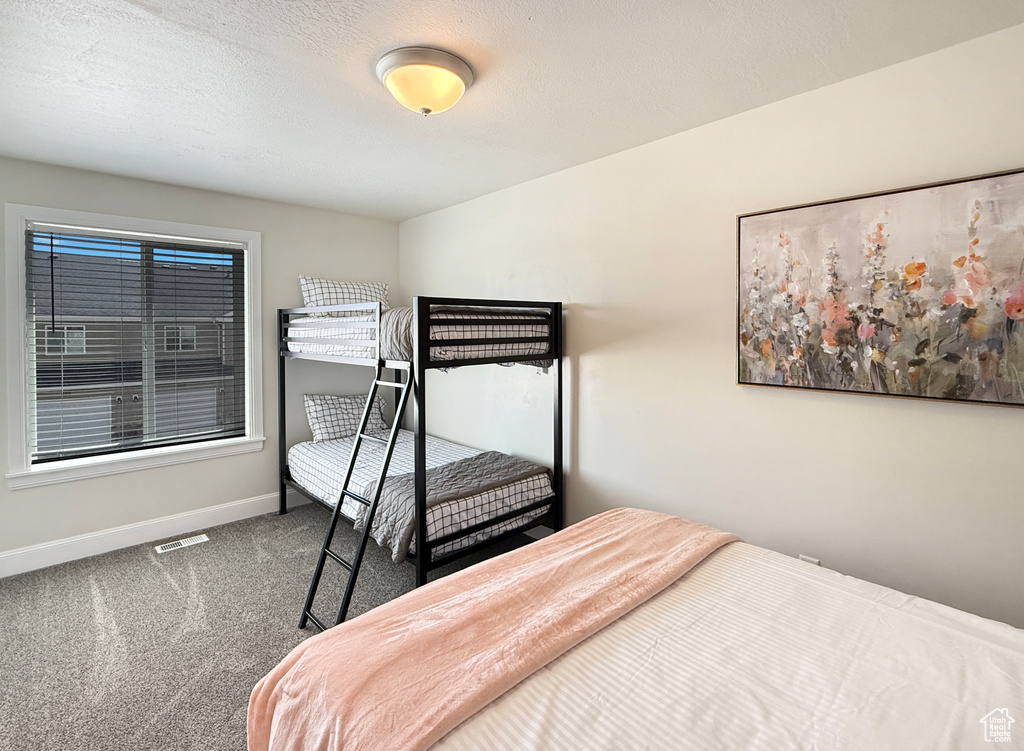 Bedroom with visible vents, carpet flooring, and baseboards