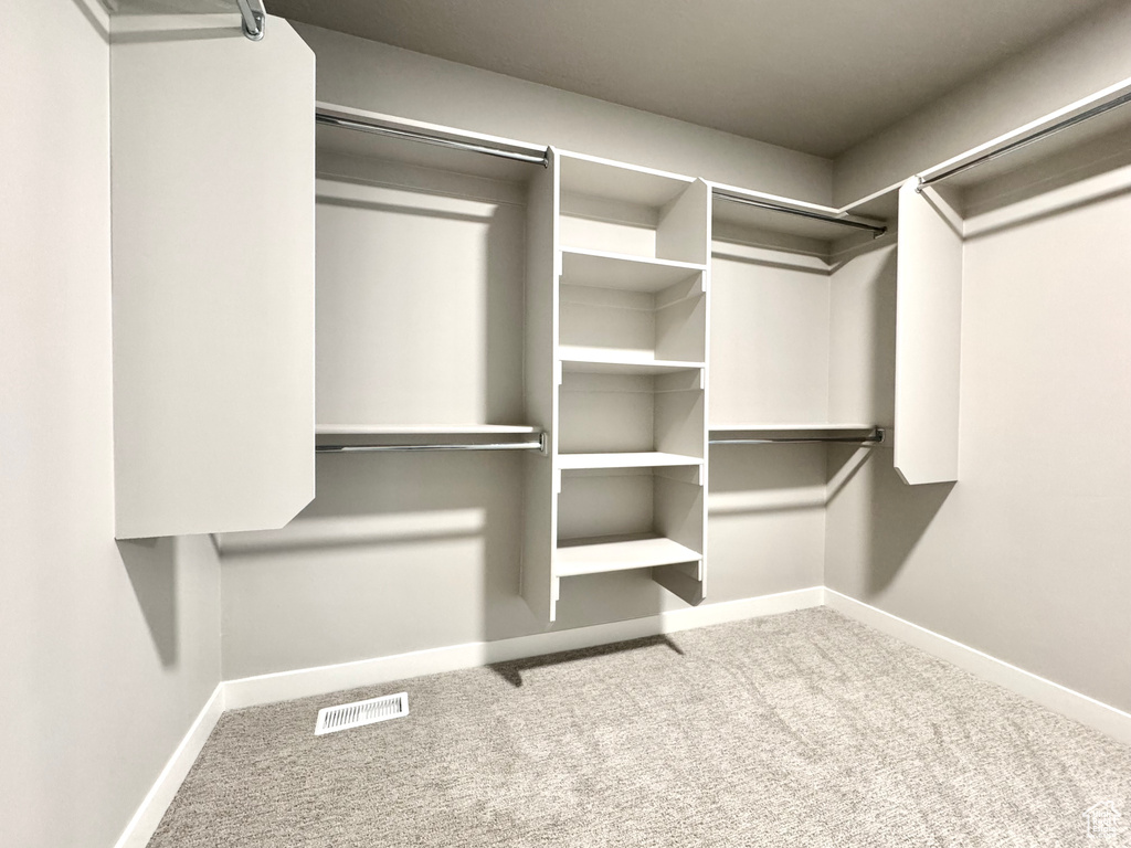 Walk in closet with visible vents and carpet floors
