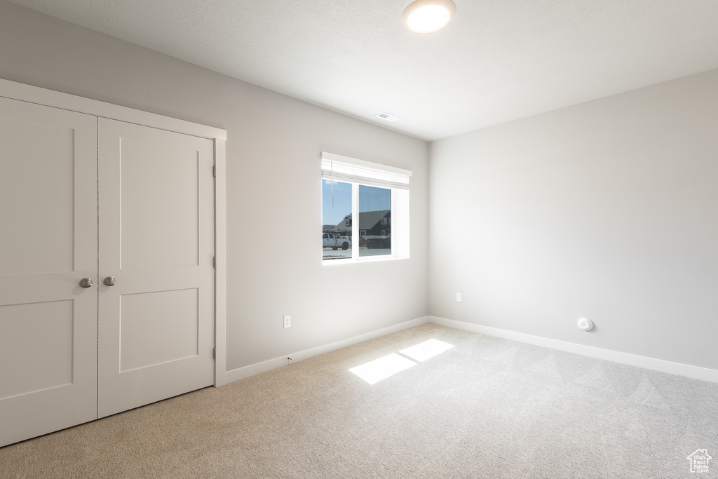 Unfurnished bedroom with carpet floors, a closet, and baseboards