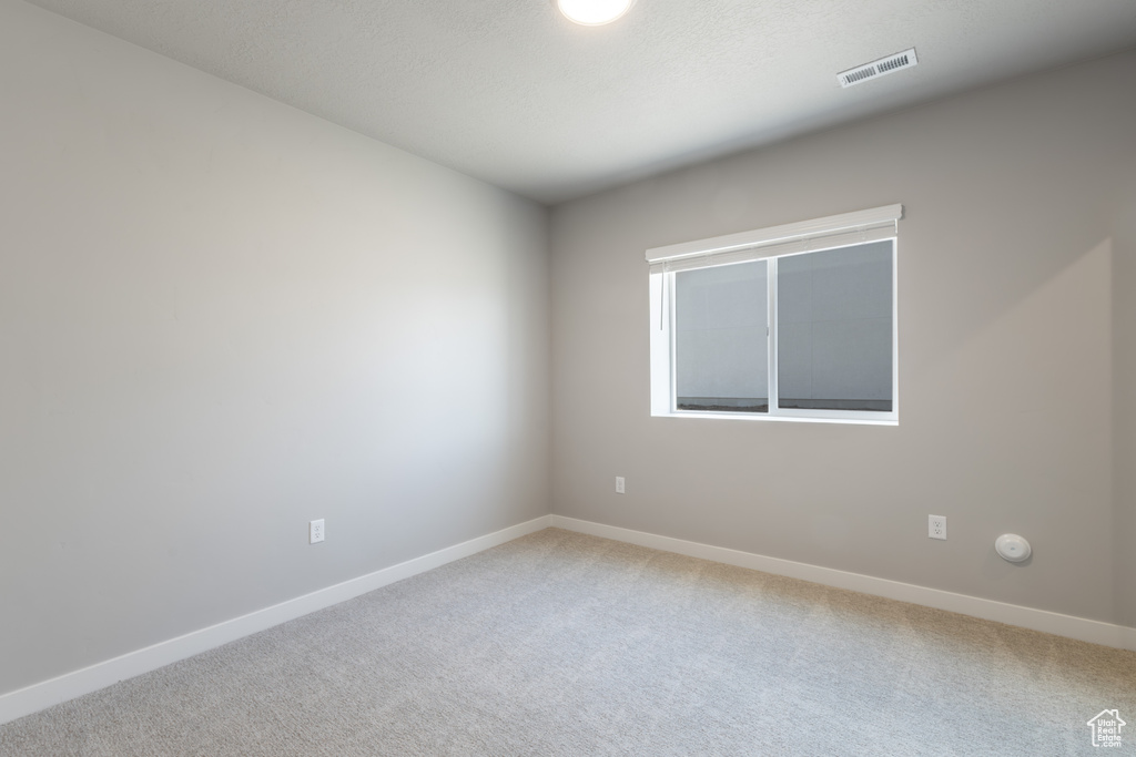 Empty room with baseboards, carpet flooring, and visible vents