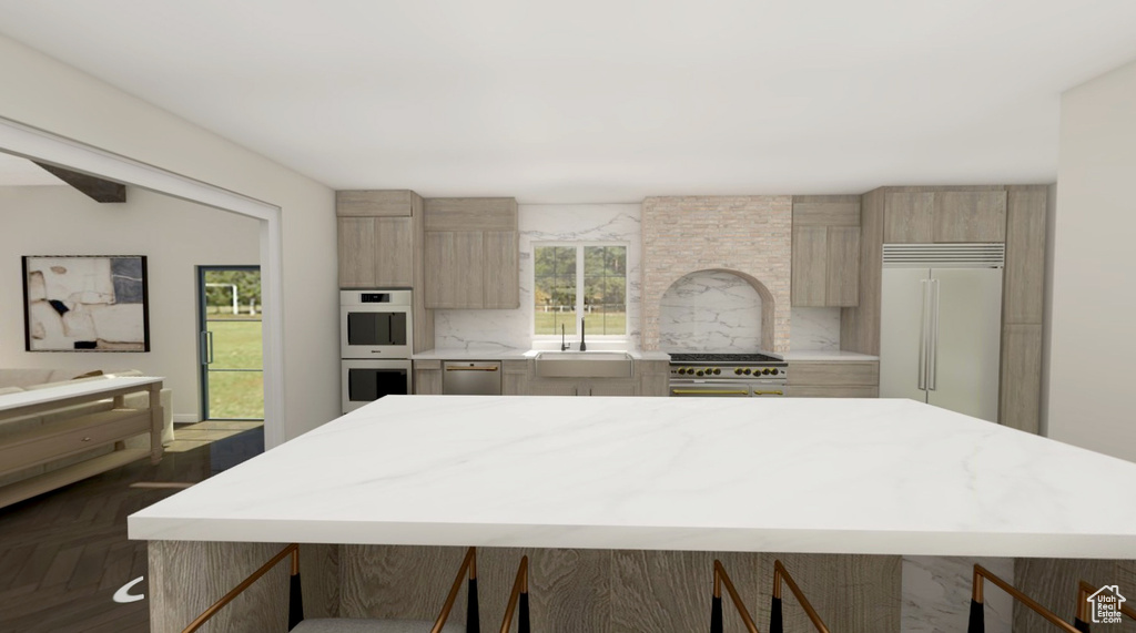 Kitchen featuring a kitchen island, backsplash, high quality appliances, a sink, and light countertops