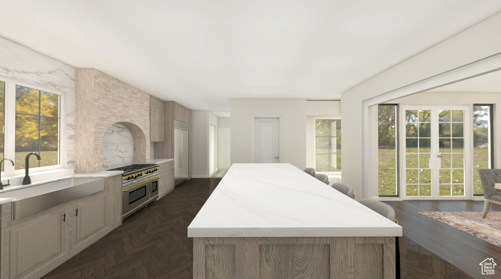 Kitchen with a sink, a kitchen island, and double oven range