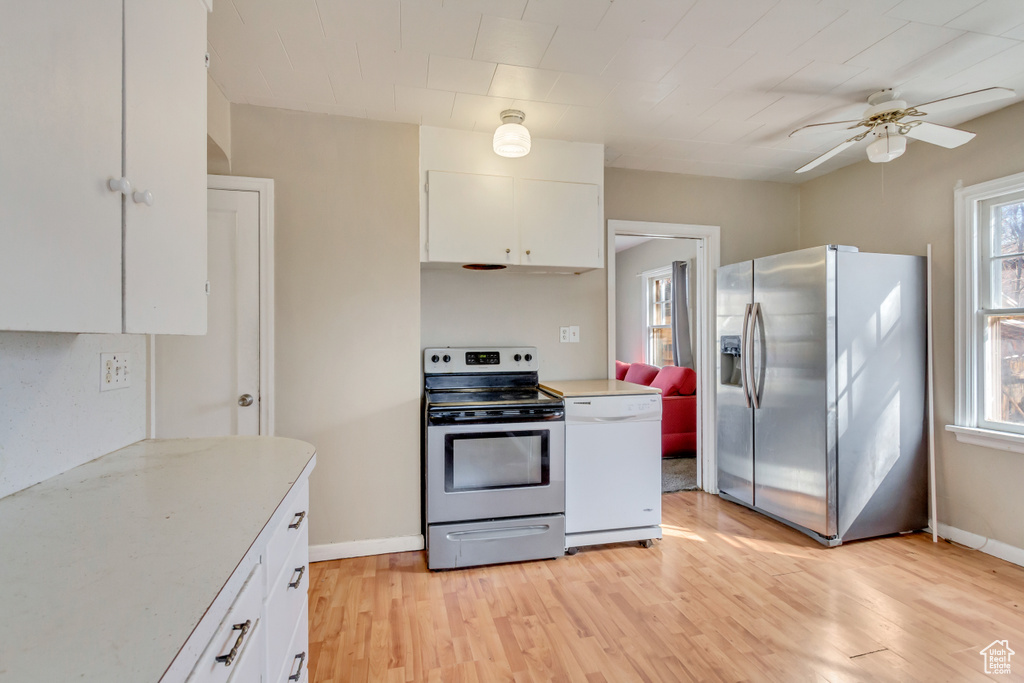 Kitchen featuring white cabinetry, stainless steel appliances, light countertops, light wood finished floors, and a ceiling fan