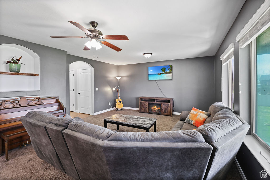 Carpeted living room with baseboards and a ceiling fan