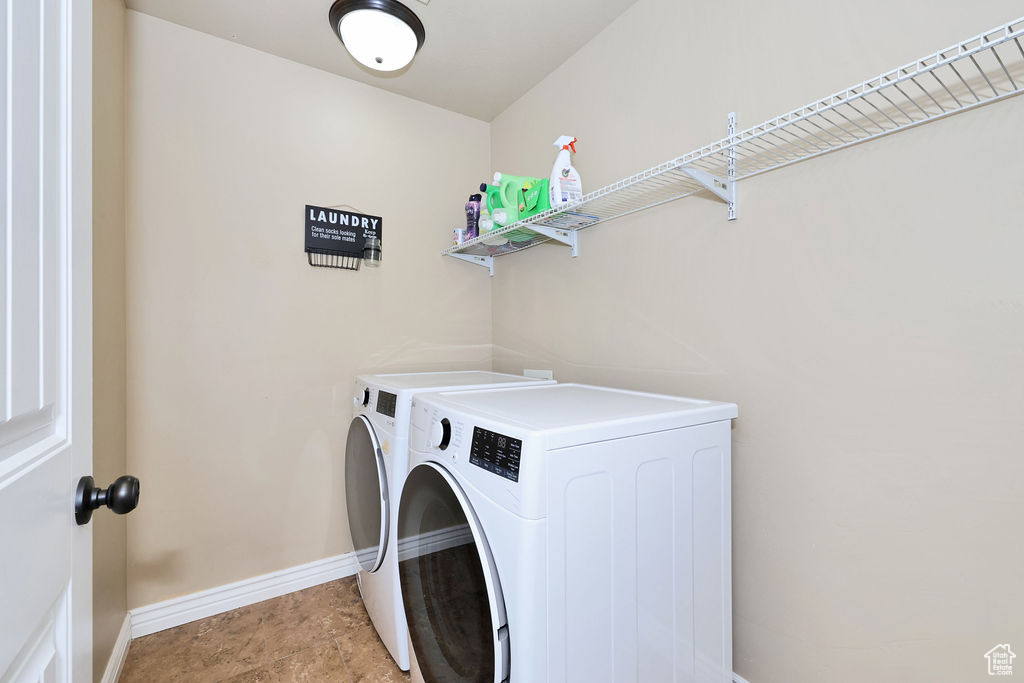 Clothes washing area featuring washer and dryer, baseboards, and laundry area