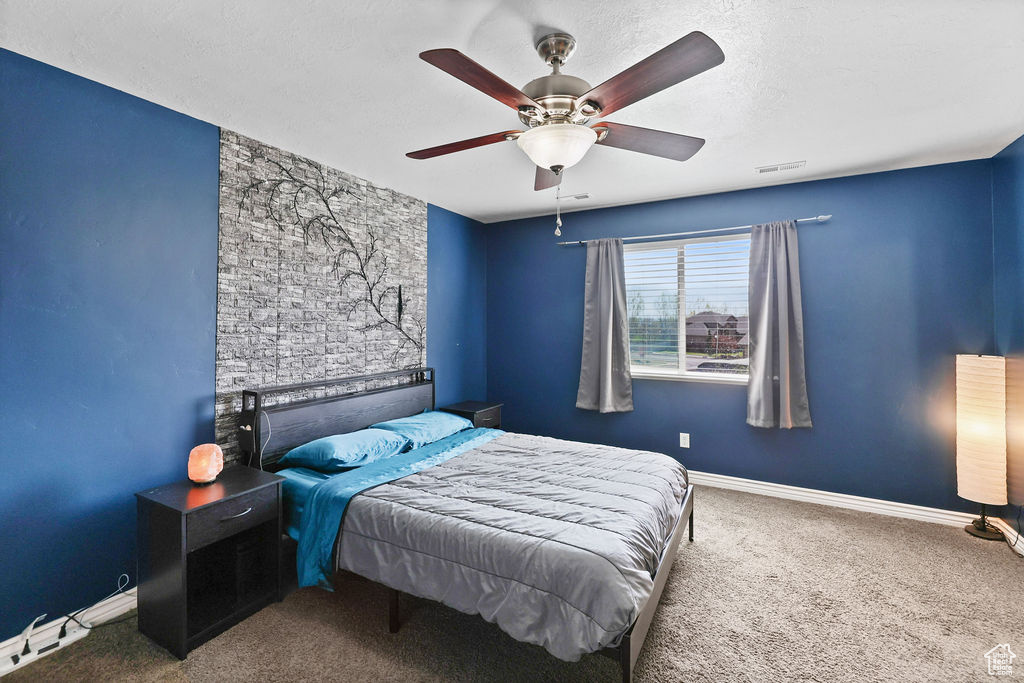 Bedroom featuring ceiling fan, baseboards, carpet flooring, and visible vents