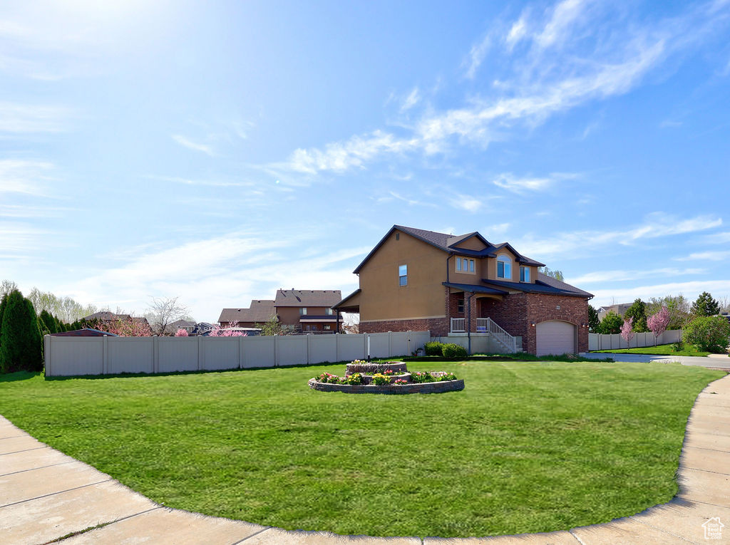Exterior space featuring a lawn, brick siding, and fence