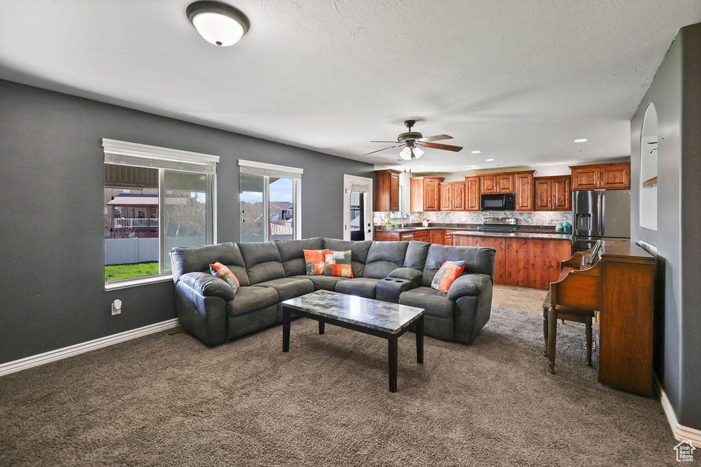 Carpeted living room featuring recessed lighting, a ceiling fan, and baseboards