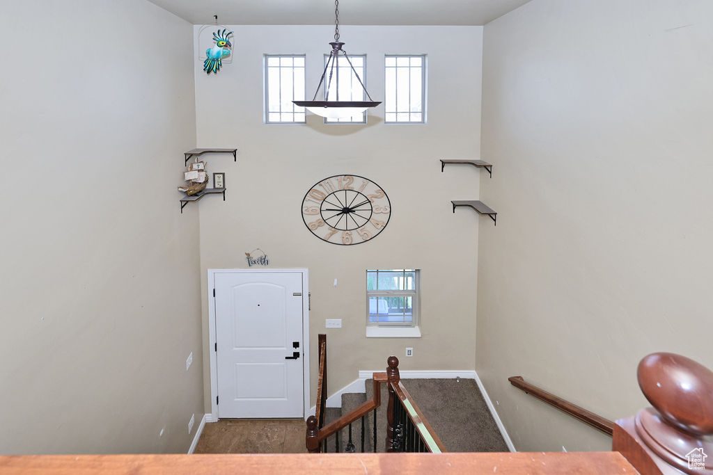 Entrance foyer featuring baseboards, a towering ceiling, and stairs
