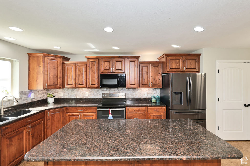 Kitchen featuring a center island, appliances with stainless steel finishes, a sink, and recessed lighting