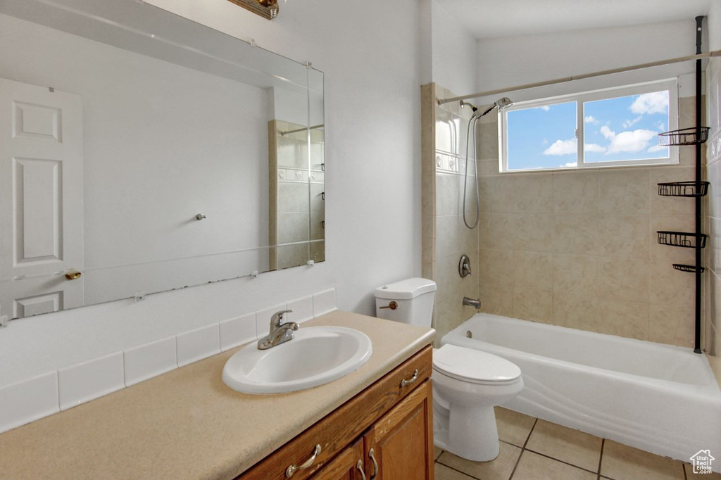 Bathroom with tile patterned floors, vanity, toilet, and shower / tub combination