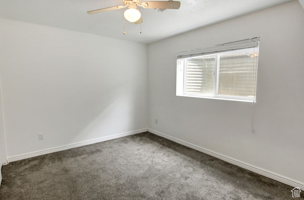 Spare room featuring ceiling fan, baseboards, and carpet floors
