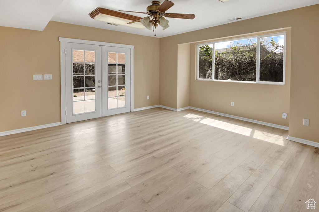 Spare room with light wood-style flooring, visible vents, baseboards, french doors, and a ceiling fan