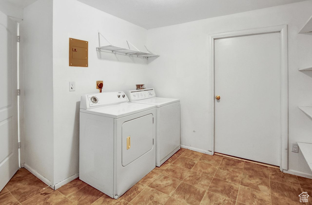 Clothes washing area with washer and dryer, electric panel, and laundry area