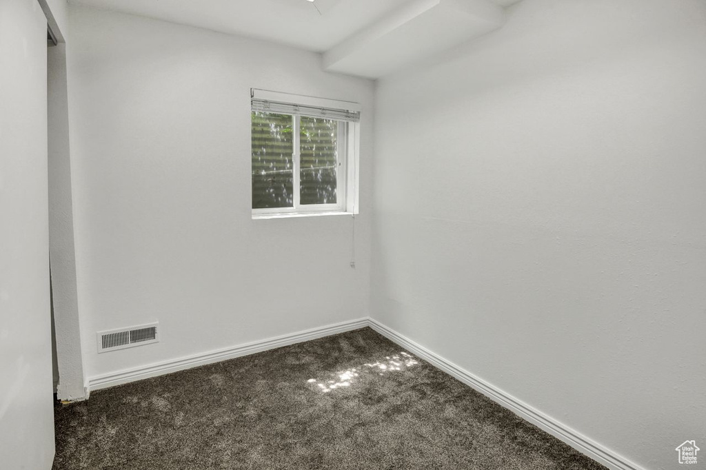 Empty room featuring baseboards, visible vents, and carpet floors
