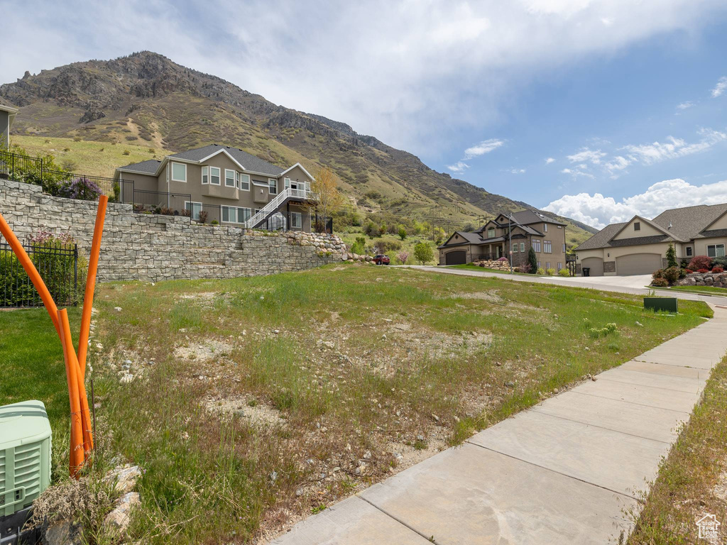 View of front facade with fence, a mountain view, and a residential view